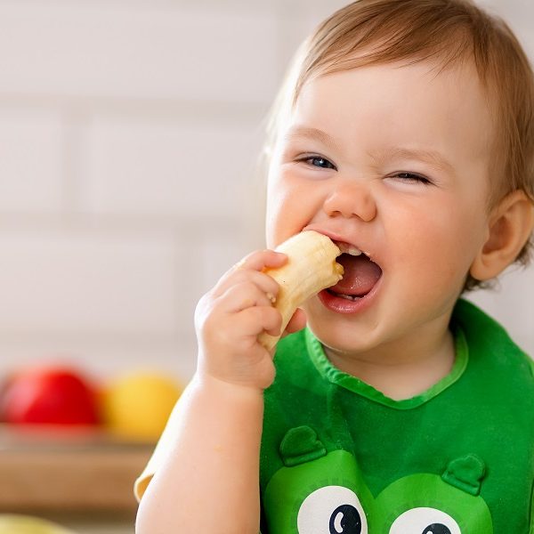 Happy child girl in the kitchen eats tasty fruits, sweet oranges. Happy child girl in the kitchen eats tasty fruits, sweet oranges.